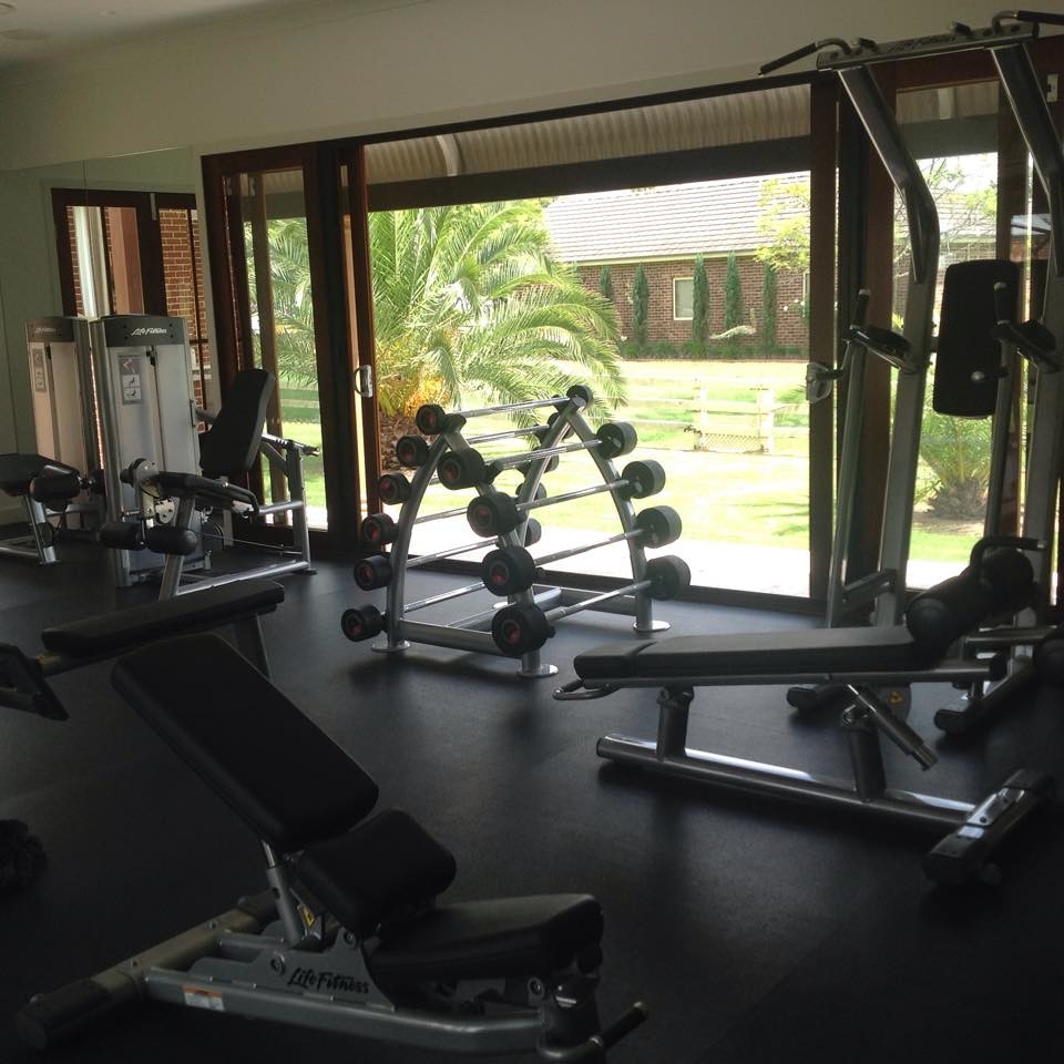 Photo of a large contemporary home gym in Sydney with black floor.