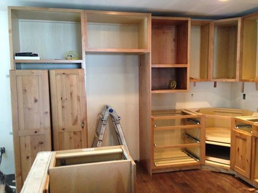 Inspiration for a mid-sized rustic u-shaped dark wood floor eat-in kitchen remodel in Denver with an undermount sink, flat-panel cabinets, light wood cabinets, granite countertops, green backsplash, glass tile backsplash, stainless steel appliances and a peninsula