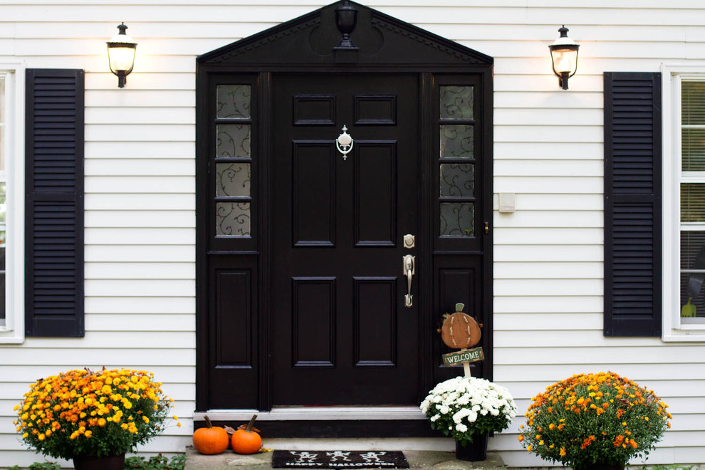 This is an example of a traditional entryway in New York with a black front door.