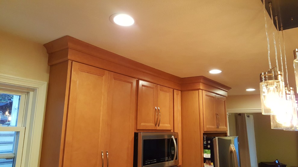 Kitchen - transitional light wood floor kitchen idea in Boston with an undermount sink, shaker cabinets, granite countertops, glass tile backsplash, stainless steel appliances and an island