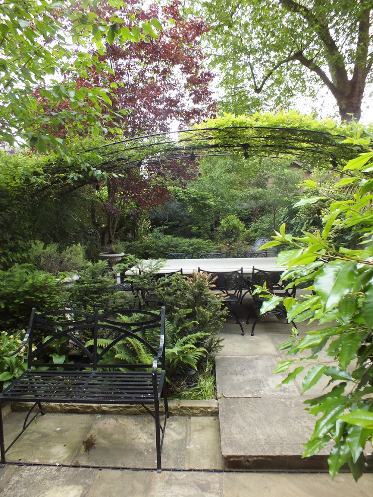 Photo of a small traditional backyard stone formal garden in London.