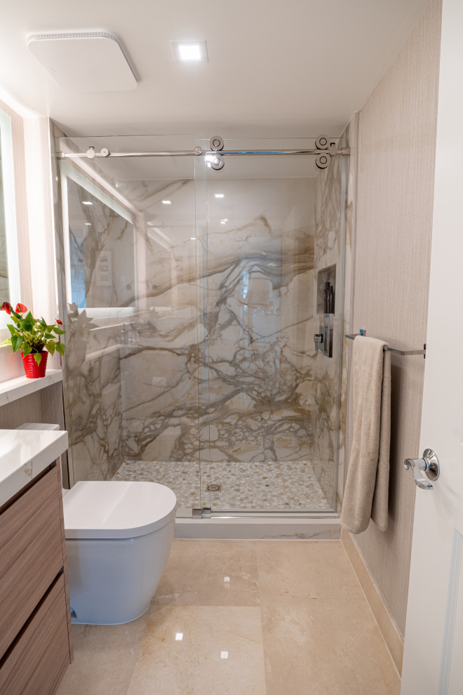 Photo of a mid-sized modern 3/4 bathroom in Miami with flat-panel cabinets, light wood cabinets, an alcove shower, a two-piece toilet, multi-coloured tile, stone slab, beige walls, marble floors, an undermount sink, engineered quartz benchtops, beige floor, a sliding shower screen, beige benchtops, a niche, a single vanity, a floating vanity and wallpaper.