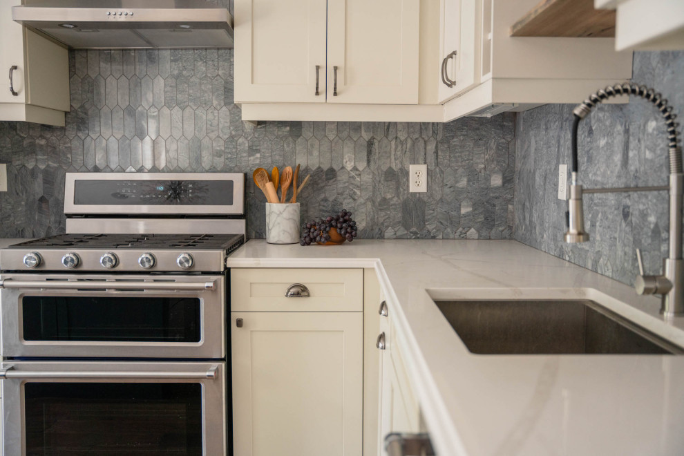 Eat-in kitchen - mid-sized transitional l-shaped dark wood floor and brown floor eat-in kitchen idea in Toronto with an undermount sink, shaker cabinets, white cabinets, quartz countertops, gray backsplash, marble backsplash, stainless steel appliances, an island and multicolored countertops