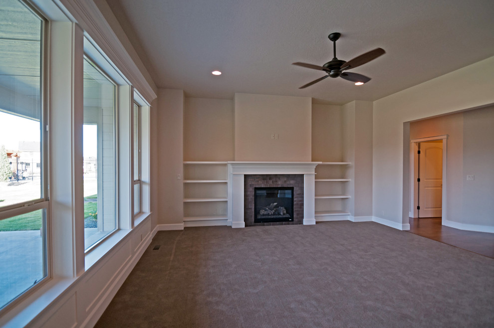 Large traditional open concept living room in Boise with beige walls, carpet, a standard fireplace, a tile fireplace surround and a wall-mounted tv.