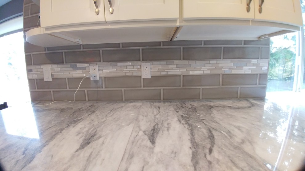 Example of a kitchen design in Seattle with granite countertops and subway tile backsplash