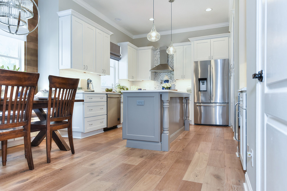 Example of a large transitional l-shaped medium tone wood floor eat-in kitchen design in Jacksonville with a farmhouse sink, shaker cabinets, quartz countertops and an island
