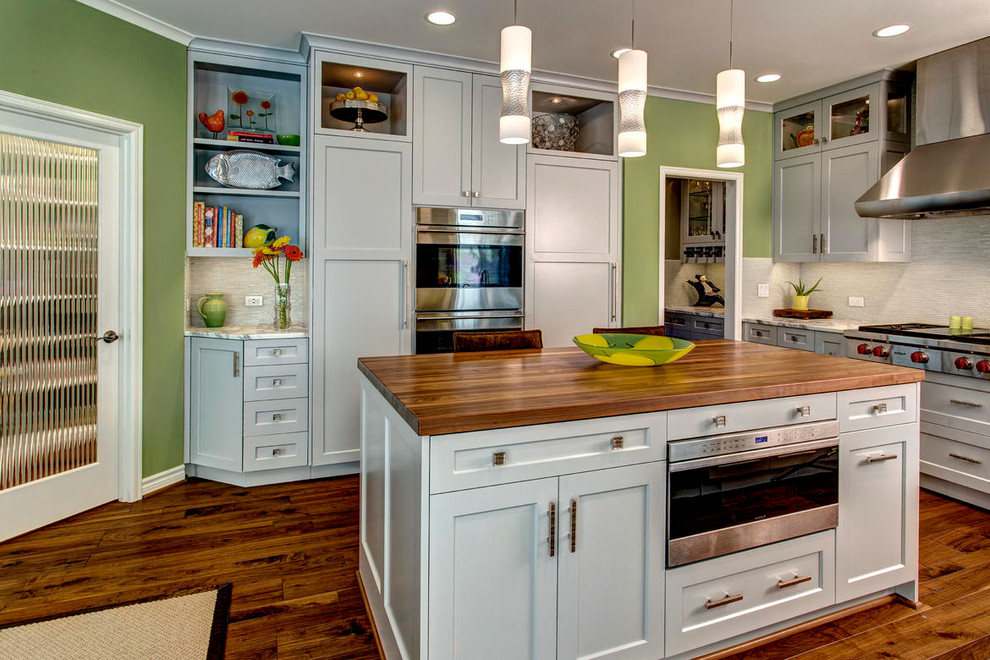 Inspiration for a large transitional u-shaped kitchen pantry in Seattle with a single-bowl sink, grey cabinets, white splashback, stainless steel appliances, dark hardwood floors and with island.