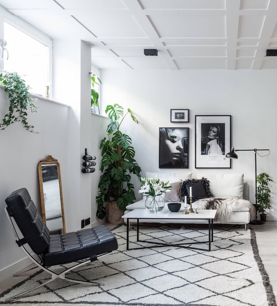 This is an example of a mid-sized scandinavian formal open concept living room in Stockholm with no tv, white walls, light hardwood floors and no fireplace.