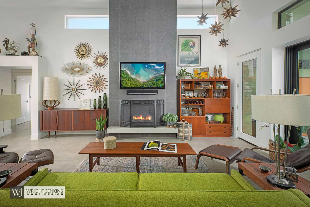 Mid-sized midcentury open concept living room in Other with white walls, concrete floors, a standard fireplace, a tile fireplace surround, a wall-mounted tv, grey floor and exposed beam.