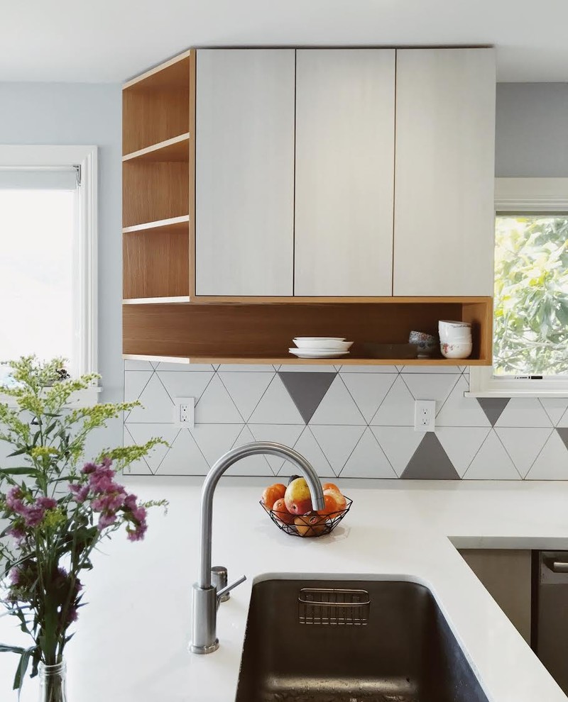 Inspiration for a mid-sized l-shaped eat-in kitchen in San Francisco with an undermount sink, flat-panel cabinets, light wood cabinets, marble benchtops, white splashback, porcelain splashback, stainless steel appliances, porcelain floors, with island, white floor and white benchtop.