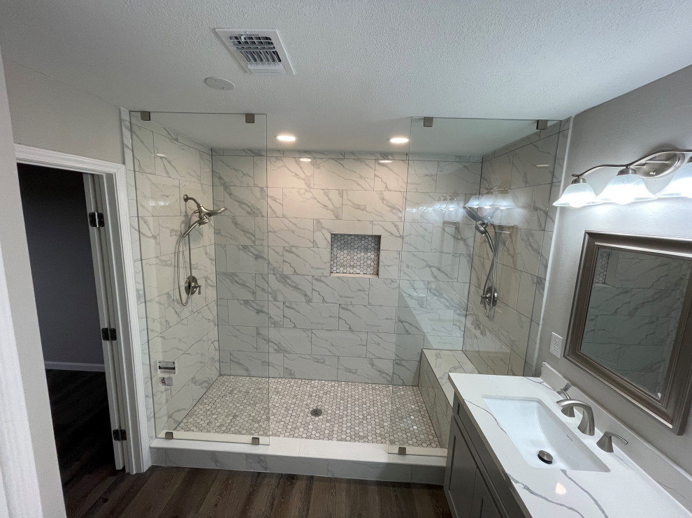 На фото: большая главная ванная комната в современном стиле с фасадами в стиле шейкер, серыми фасадами, двойным душем, столешницей из искусственного кварца, белой столешницей, тумбой под две раковины и встроенной тумбой