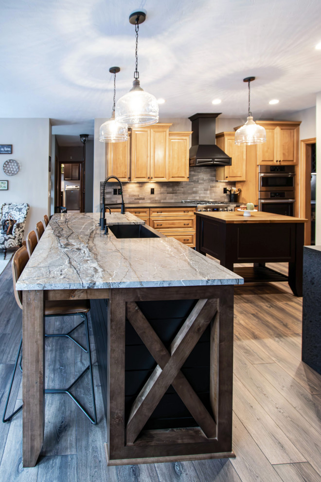 Inspiration for a large transitional u-shaped eat-in kitchen in Cleveland with flat-panel cabinets, black cabinets, granite benchtops, multiple islands and black benchtop.