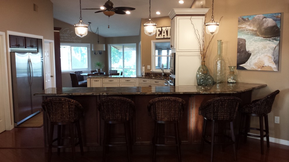 Eat-in kitchen - mid-sized transitional l-shaped dark wood floor and brown floor eat-in kitchen idea with an undermount sink, raised-panel cabinets, white cabinets, granite countertops, stainless steel appliances, a peninsula and brown countertops