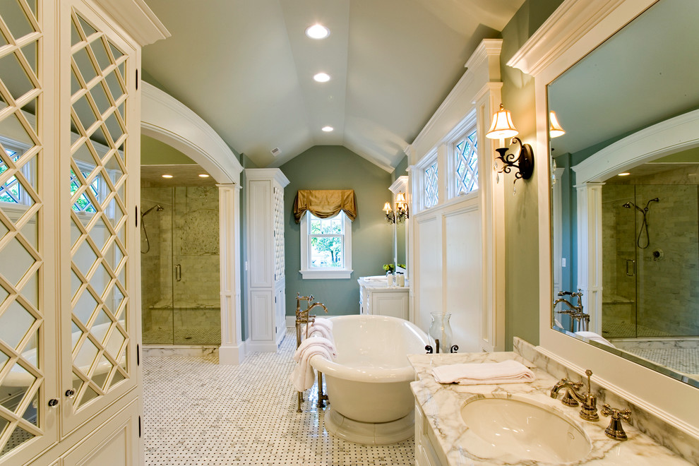 This is an example of a traditional bathroom in Chicago with a freestanding tub, marble benchtops and an undermount sink.