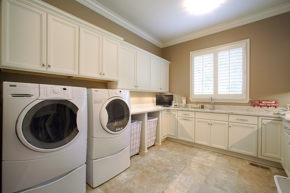This is an example of a large transitional u-shaped dedicated laundry room in Birmingham with an undermount sink, shaker cabinets, white cabinets, quartzite benchtops, beige walls, ceramic floors, a side-by-side washer and dryer and beige floor.
