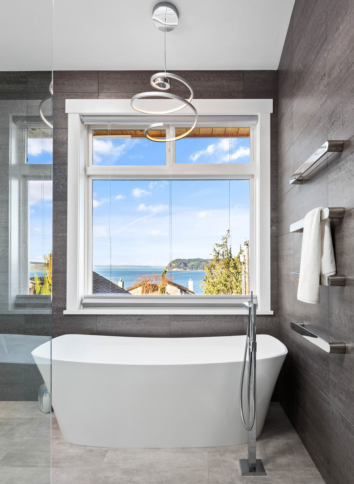 This is an example of a large contemporary master bathroom in Seattle with flat-panel cabinets, black cabinets, a freestanding tub, a curbless shower, gray tile, porcelain tile, grey walls, porcelain floors, an undermount sink, engineered quartz benchtops, grey floor, an open shower and white benchtops.