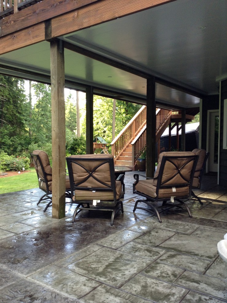 Example of a mid-sized transitional backyard stamped concrete patio design in Seattle with a fire pit