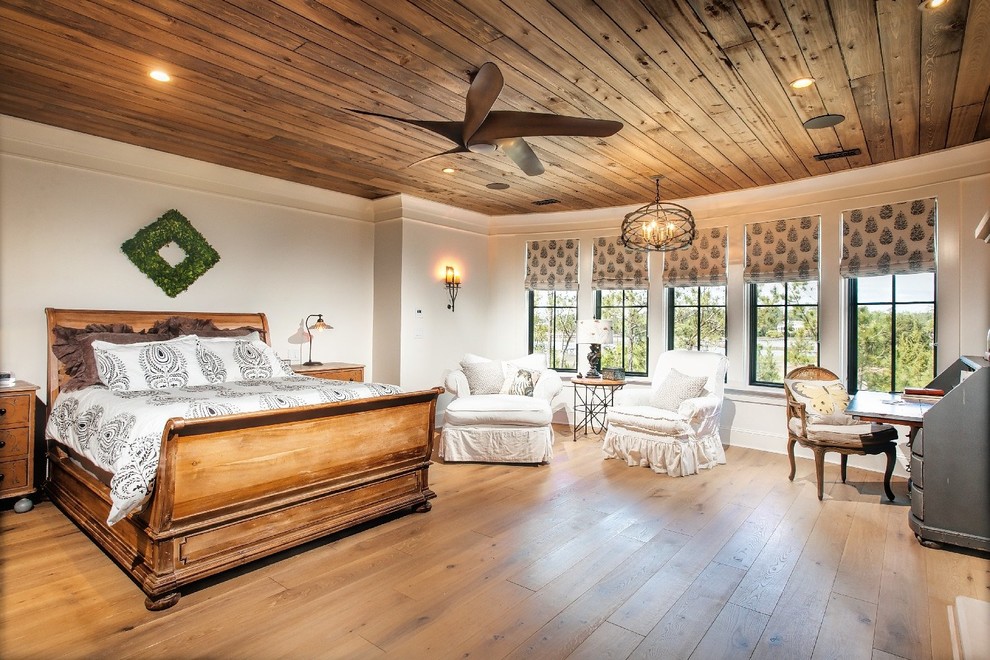 Photo of a traditional master bedroom in Charleston with white walls and light hardwood floors.