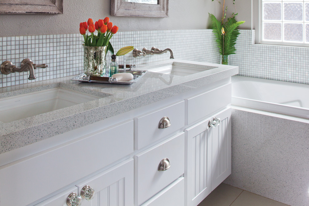 Inspiration for a small traditional 3/4 bathroom in Miami with an undermount sink, flat-panel cabinets, white cabinets, recycled glass benchtops, an alcove tub, white tile, glass tile and beige walls.