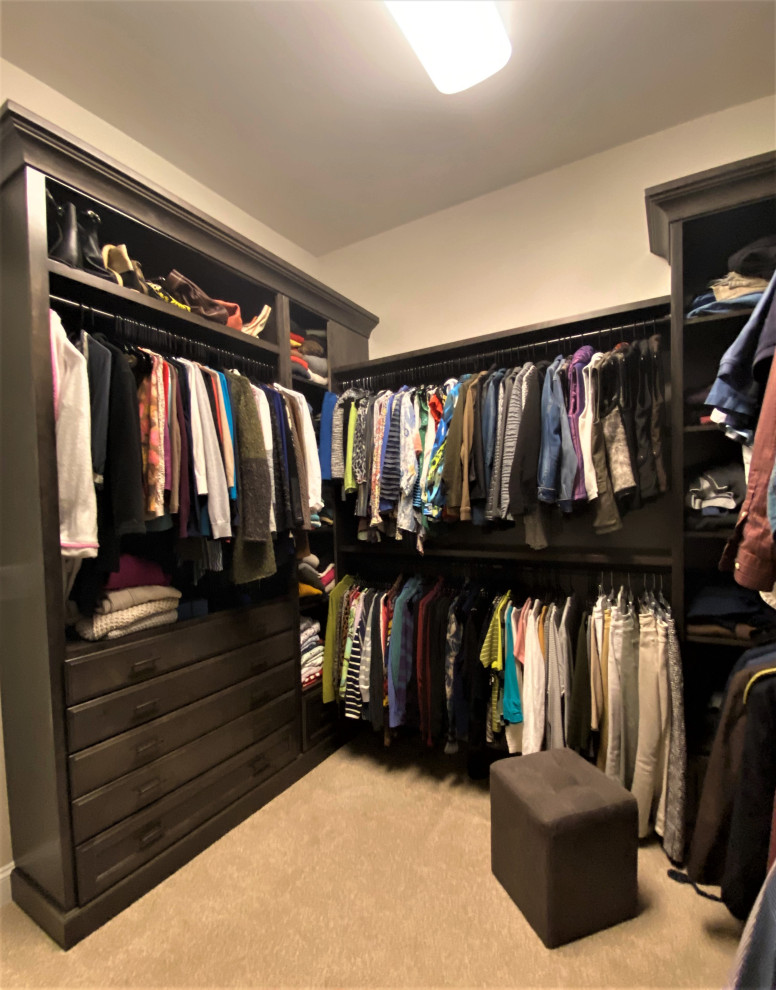 This is an example of a large transitional walk-in wardrobe in DC Metro with recessed-panel cabinets, grey cabinets, carpet and beige floor.