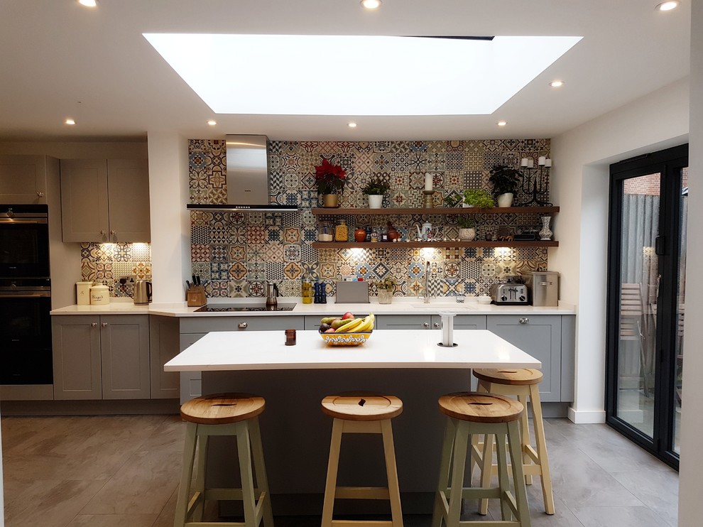 Inspiration for a mid-sized contemporary single-wall kitchen in Buckinghamshire with an undermount sink, recessed-panel cabinets, grey cabinets, quartzite benchtops, multi-coloured splashback, ceramic splashback, stainless steel appliances, with island, grey floor and white benchtop.