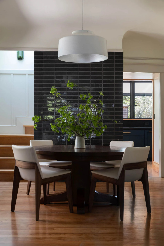 Inspiration pour une salle à manger minimaliste avec un mur noir et un mur en parement de brique.