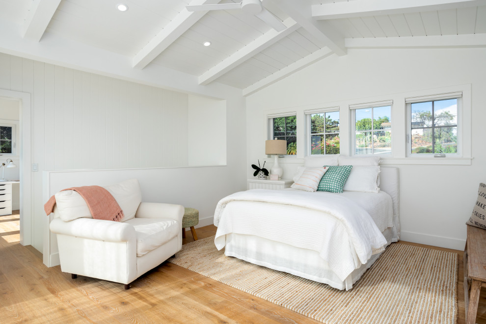 Photo of a mid-sized transitional loft-style bedroom in San Diego with white walls, medium hardwood floors and beige floor.