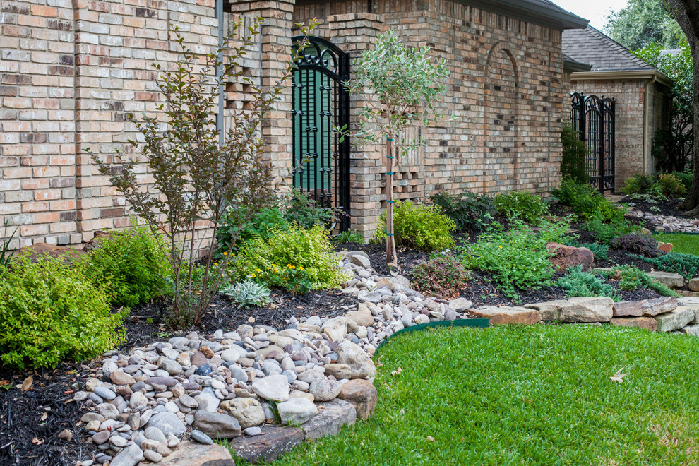 This is an example of a mid-sized eclectic front yard full sun xeriscape in Dallas with a garden path and natural stone pavers.