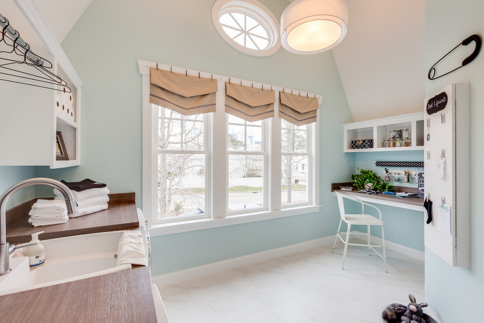 Design ideas for a large beach style u-shaped utility room in Other with recessed-panel cabinets, white cabinets, laminate benchtops, blue walls, marble floors, a side-by-side washer and dryer and a farmhouse sink.