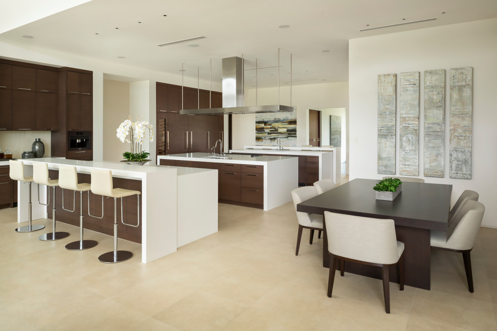 Photo of an expansive modern open plan kitchen in Phoenix with an undermount sink, flat-panel cabinets, dark wood cabinets, solid surface benchtops, panelled appliances, travertine floors, multiple islands, white floor and white benchtop.