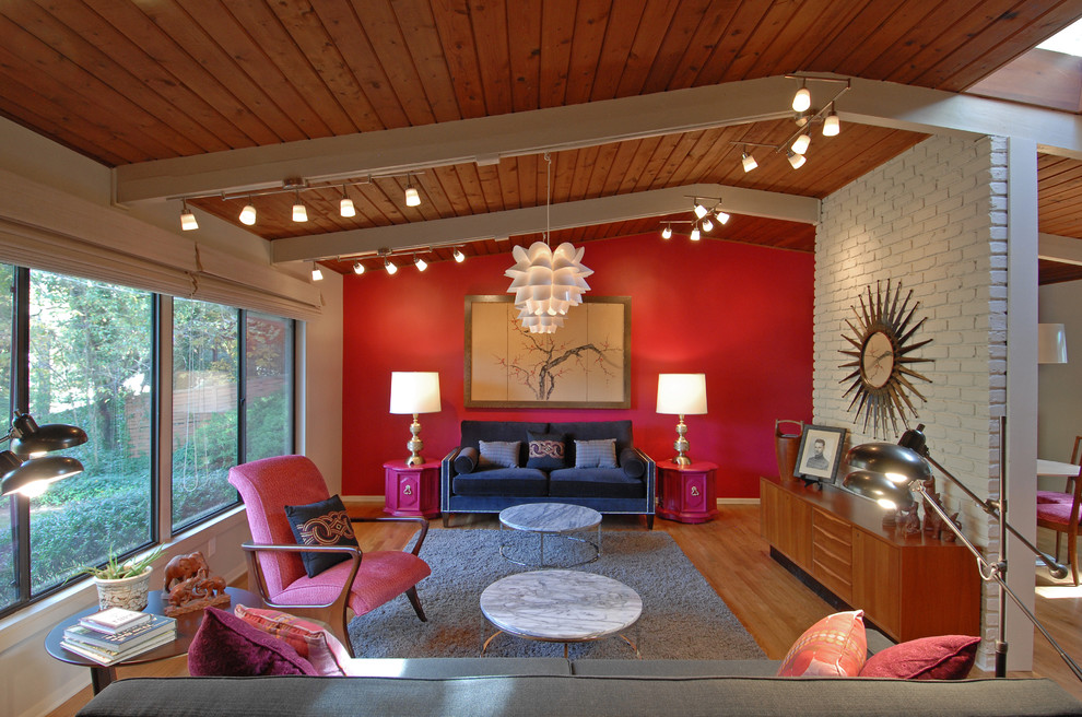 Inspiration for a modern living room in Atlanta with red walls, medium hardwood floors, no fireplace and no tv.