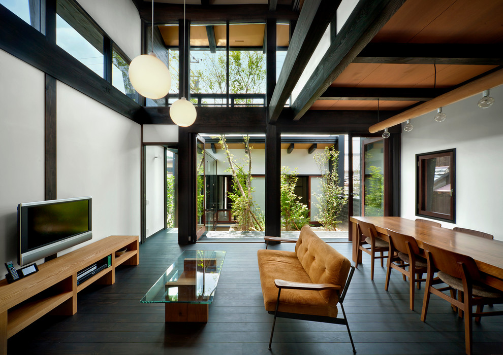 Photo of an asian living room in Osaka with white walls, dark hardwood floors, a wall-mounted tv and black floor.
