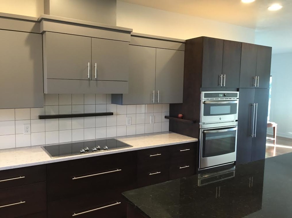 Inspiration for a mid-sized transitional single-wall eat-in kitchen remodel in Cedar Rapids with flat-panel cabinets, gray cabinets, quartz countertops, white backsplash, ceramic backsplash, stainless steel appliances and an island