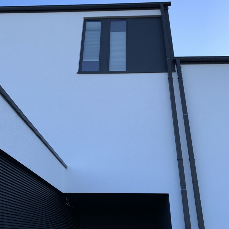 На фото: трехэтажный, бежевый дом среднего размера в стиле модернизм с комбинированной облицовкой, двускатной крышей, крышей из смешанных материалов, черной крышей и отделкой доской с нащельником