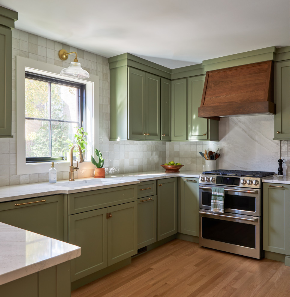 Example of a small eclectic u-shaped light wood floor and brown floor open concept kitchen design in Chicago with a single-bowl sink, shaker cabinets, green cabinets, quartz countertops, white backsplash, ceramic backsplash, stainless steel appliances, a peninsula and white countertops