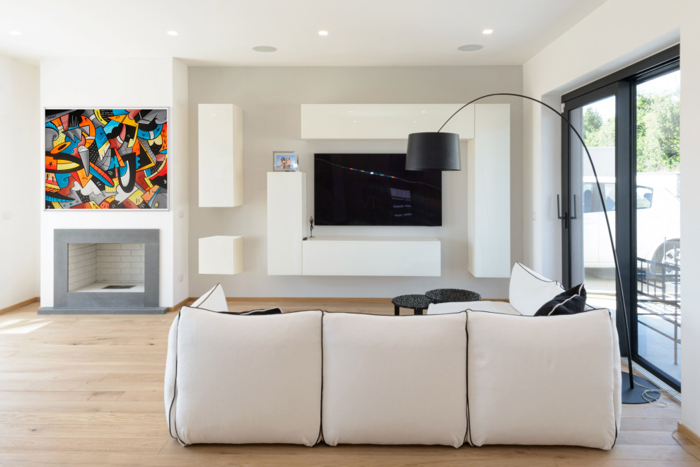 Ispirazione per un soggiorno minimalista con pareti bianche, parquet chiaro e TV a parete