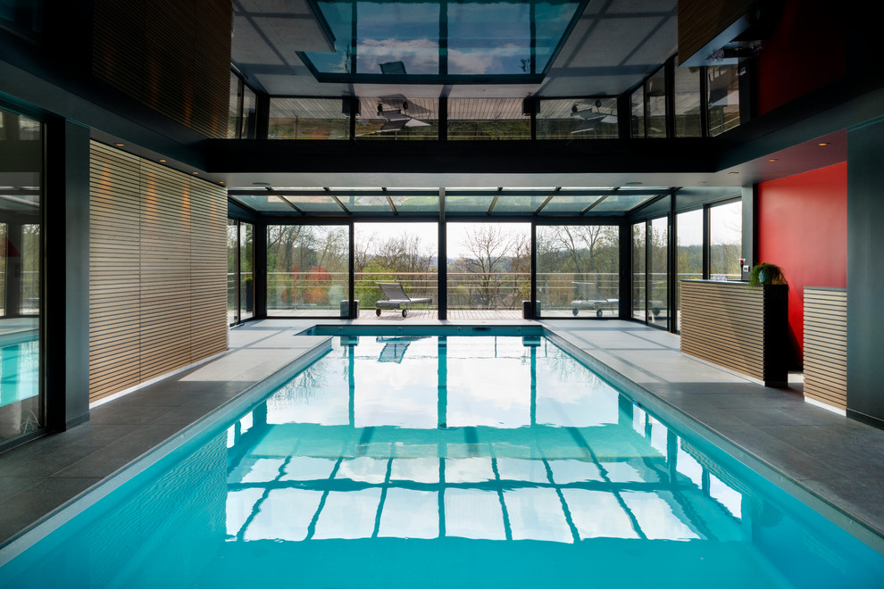 This is an example of a large contemporary indoor rectangular lap pool in Le Havre with tile.