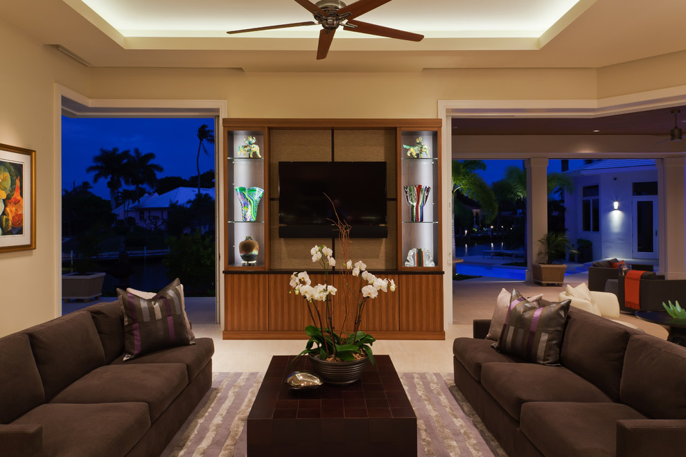 Contemporary open concept living room in Miami with a wall-mounted tv, beige walls and limestone floors.