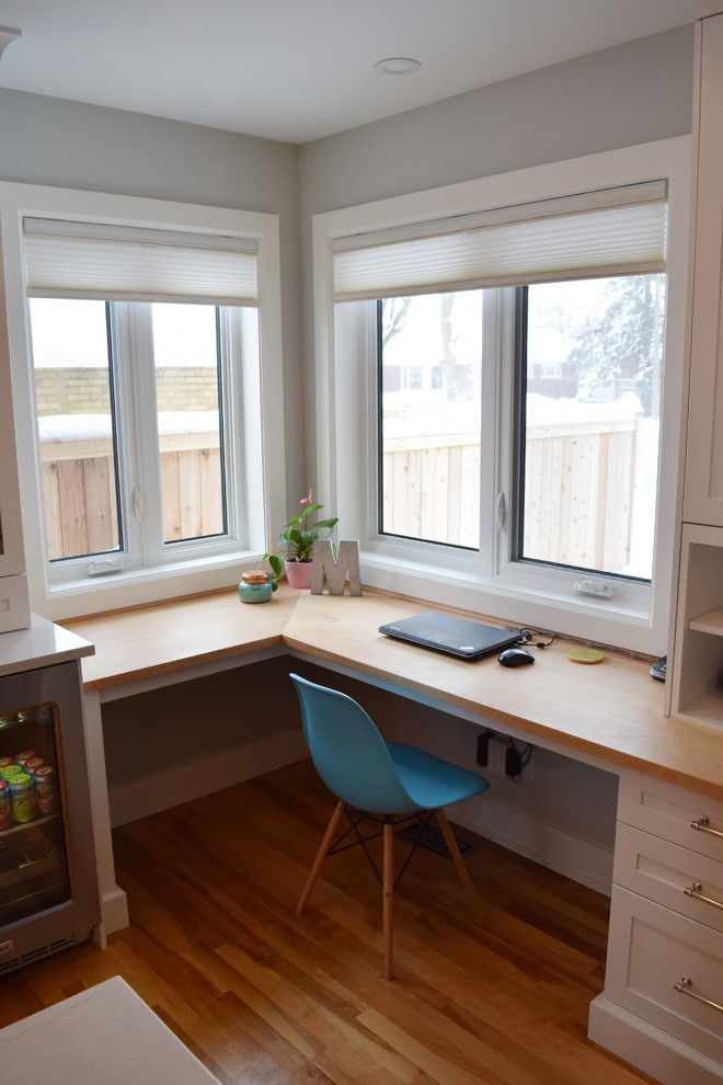 Example of a large transitional l-shaped light wood floor open concept kitchen design in Ottawa with an undermount sink, shaker cabinets, white cabinets, quartz countertops, white backsplash, subway tile backsplash, stainless steel appliances and an island
