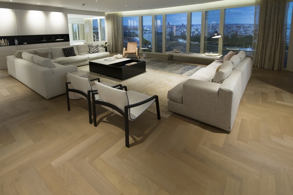 Design ideas for a large contemporary open concept living room in London with light hardwood floors.