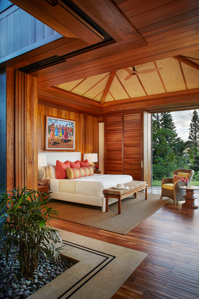 Design ideas for an expansive tropical guest bedroom in Hawaii with multi-coloured walls and dark hardwood floors.