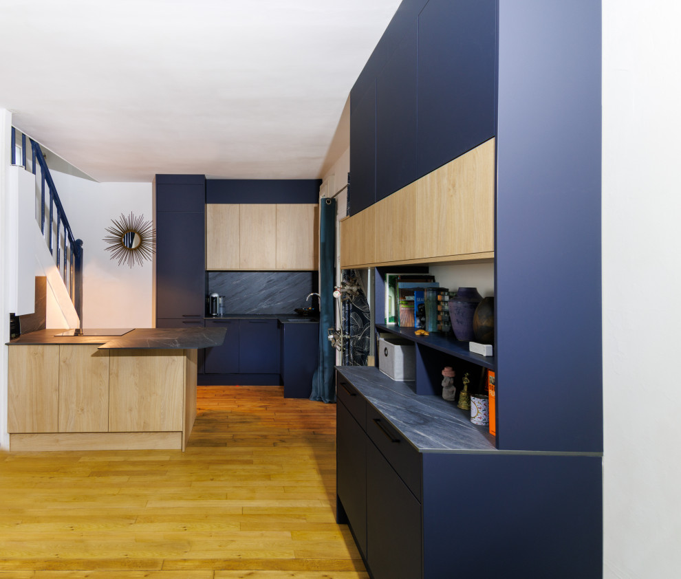 Свежая идея для дизайна: кухня в современном стиле с светлыми деревянными фасадами, серым фартуком и серой столешницей - отличное фото интерьера
