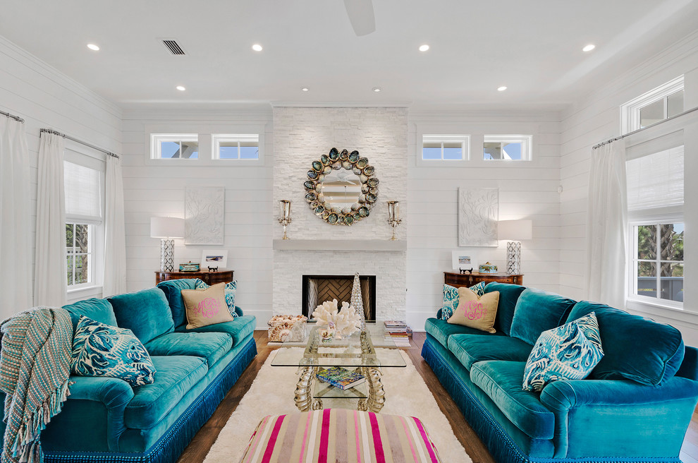 This is an example of a beach style living room in Miami with white walls, dark hardwood floors, a standard fireplace and a stone fireplace surround.