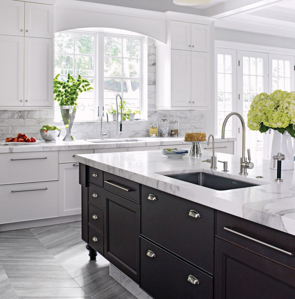 This is an example of an expansive transitional u-shaped eat-in kitchen in New York with an undermount sink, shaker cabinets, white cabinets, marble benchtops, white splashback, stainless steel appliances, marble floors and with island.