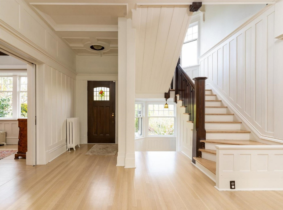 他の地域にあるヴィクトリアン調のおしゃれな玄関ロビー (淡色無垢フローリング、ベージュの床、パネル壁) の写真