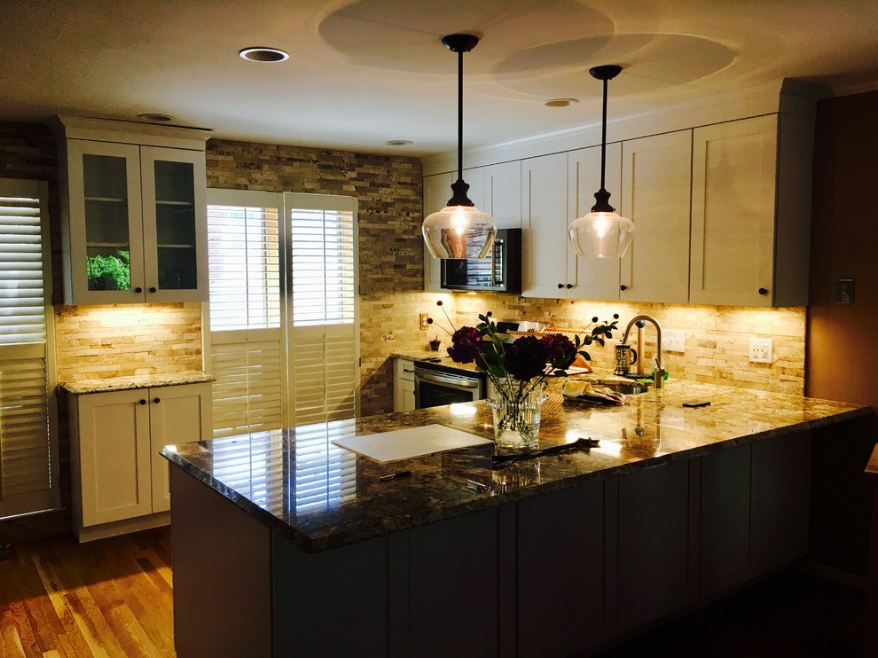 Inspiration for a mid-sized transitional l-shaped medium tone wood floor and brown floor open concept kitchen remodel in DC Metro with an undermount sink, shaker cabinets, white cabinets, granite countertops, beige backsplash, stone tile backsplash, stainless steel appliances and a peninsula