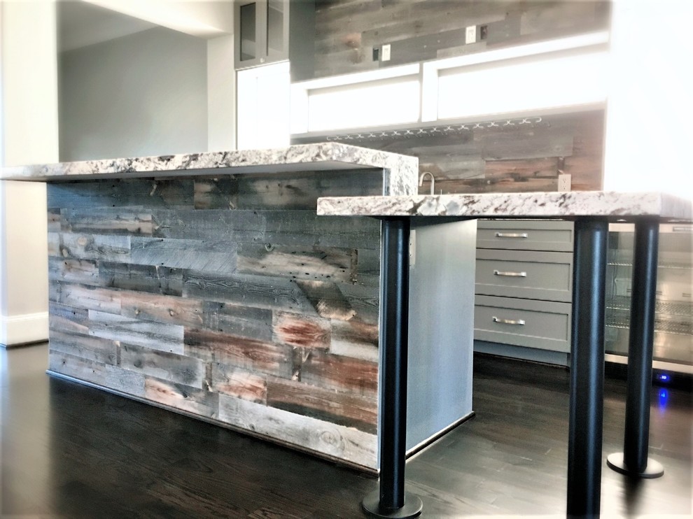 Mid-sized traditional l-shaped open plan kitchen in Houston with a farmhouse sink, shaker cabinets, grey cabinets, granite benchtops, grey splashback, timber splashback, stainless steel appliances, dark hardwood floors and with island.