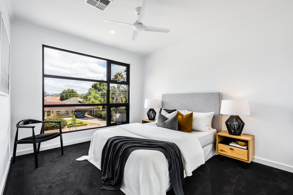 Mid-sized contemporary guest bedroom in Adelaide with white walls, carpet and grey floor.