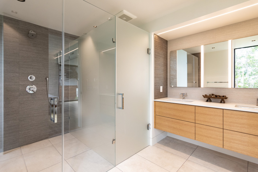Photo of a medium sized modern ensuite bathroom in San Francisco with flat-panel cabinets, medium wood cabinets, a built-in shower, multi-coloured tiles, ceramic tiles, ceramic flooring, a submerged sink, quartz worktops, beige floors, a hinged door, white worktops, an enclosed toilet, double sinks and a floating vanity unit.
