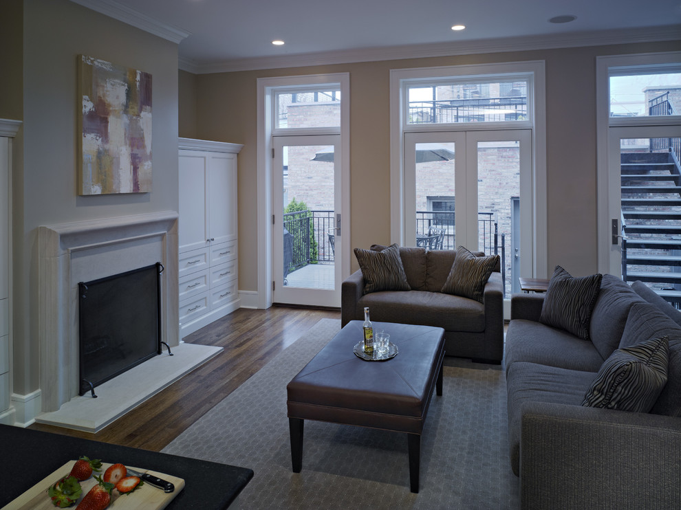 This is an example of a mid-sized open concept family room in Chicago with grey walls, medium hardwood floors, a standard fireplace and a stone fireplace surround.